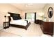 Bright bedroom with a dark wood bed, desk area by the window, and light wood flooring at 9573 Southern Garden Cir, Altamonte Springs, FL 32714