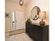Inviting entryway featuring a white front door, black console table with round mirror, and neutral tile flooring at 9573 Southern Garden Cir, Altamonte Springs, FL 32714