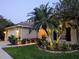 Attractive home with lovely landscaping, exterior lighting, a well-manicured lawn, and a two-car garage in the evening at 9573 Southern Garden Cir, Altamonte Springs, FL 32714