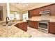 Charming kitchen with granite countertops, stainless steel appliances, and dark wood cabinets with plenty of natural light at 9573 Southern Garden Cir, Altamonte Springs, FL 32714