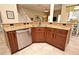 Kitchen featuring granite countertops and stainless steel dishwasher with dark cabinets and tile flooring at 9573 Southern Garden Cir, Altamonte Springs, FL 32714