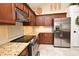 Close-up of a well-appointed kitchen featuring stainless steel appliances, granite counters, and wooden cabinets at 9573 Southern Garden Cir, Altamonte Springs, FL 32714