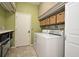 Well-lit laundry room with modern washer and dryer, plus storage shelves and tiled floors at 9573 Southern Garden Cir, Altamonte Springs, FL 32714