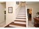 Bright stairway featuring white risers and stained wood treads, with neutral walls and tile flooring at 9573 Southern Garden Cir, Altamonte Springs, FL 32714
