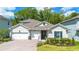 Charming home with a well-manicured lawn, a two-car garage, and a beautifully landscaped front yard at 1005 Talon Pl, Winter Springs, FL 32708