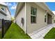 A view of the side of the home with a grass, side yard, and stone pavers at 1005 Talon Pl, Winter Springs, FL 32708