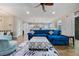 Bright living room featuring a blue velvet sectional, modern ceiling fan and dark, hardwood floors at 1005 Talon Pl, Winter Springs, FL 32708