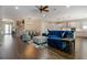 Open living space features hardwood flooring, modern lighting, a blue sectional, and a view to the kitchen at 1005 Talon Pl, Winter Springs, FL 32708
