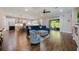 Spacious open floor plan with a large blue sectional, hardwood flooring, and modern kitchen at 1005 Talon Pl, Winter Springs, FL 32708