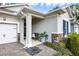 Inviting covered front porch with stone accents, lush landscaping, and a comfortable bench at 1005 Talon Pl, Winter Springs, FL 32708