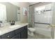 Well-lit bathroom with granite counters, tile flooring, and tub with shower at 1101 N Division St, Oviedo, FL 32765