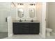 Bright bathroom features a double vanity, sleek mirrors, and a glass enclosed shower at 1101 N Division St, Oviedo, FL 32765