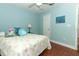 Relaxing blue bedroom features hardwood floors, ceiling fan, and lots of light at 1101 N Division St, Oviedo, FL 32765