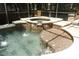 Inviting hot tub featuring tile accents and a built-in waterfall feature, surrounded by a screened enclosure at 1101 N Division St, Oviedo, FL 32765
