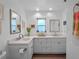 Stylish bathroom with double sinks, framed mirrors, white cabinets, and contemporary decor at 1139 Fairway Dr, Winter Park, FL 32792