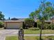 Charming home boasts a two-car garage and meticulously landscaped front yard with lush greenery at 1139 Fairway Dr, Winter Park, FL 32792