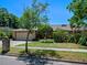 Charming home boasts a two-car garage and meticulously landscaped front yard with lush greenery at 1139 Fairway Dr, Winter Park, FL 32792