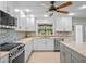 Renovated kitchen with white cabinets, mosaic backsplash, and stainless steel appliances at 1139 Fairway Dr, Winter Park, FL 32792