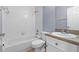 White bathroom with a shower-tub combo, toilet, vanity and neutral countertops at 1236 S Beach Cir, Kissimmee, FL 34746