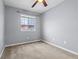 Empty bedroom painted in gray with carpeted floor and a window overlooking nearby houses at 1236 S Beach Cir, Kissimmee, FL 34746