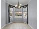 Bright dining area featuring a chandelier, tile flooring, and large windows offering neighborhood views at 1236 S Beach Cir, Kissimmee, FL 34746
