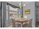 Cozy dining area with a round table illuminated by an elegant chandelier and large windows at 1236 S Beach Cir, Kissimmee, FL 34746