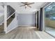 Bright living room with wood floors, stairway, ceiling fan and sliding glass door at 1236 S Beach Cir, Kissimmee, FL 34746