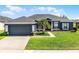 Charming single-story home boasts a well-manicured lawn and attached two-car garage at 13606 Summer Rain Dr, Orlando, FL 32828