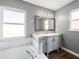 Bathroom featuring a soaking tub, white vanity with gray walls, and a bright window at 150 Bentley Oaks Blvd, Davenport, FL 33896