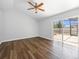 An empty bedroom with hardwood floors and a sliding glass door leading to the pool at 150 Bentley Oaks Blvd, Davenport, FL 33896