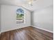 Sunlit bedroom featuring a vaulted ceiling, wood-look floors, and a large arched window at 150 Bentley Oaks Blvd, Davenport, FL 33896