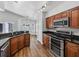 Kitchen area featuring dark wood cabinets, black countertops, and modern stainless steel appliances at 150 Bentley Oaks Blvd, Davenport, FL 33896