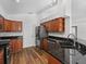 Modern kitchen with dark cabinets, stainless steel appliances, and granite countertops at 150 Bentley Oaks Blvd, Davenport, FL 33896