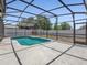 Backyard pool area featuring a screened-in pool, concrete deck and privacy fence at 150 Bentley Oaks Blvd, Davenport, FL 33896