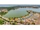 Aerial view of a lakeside neighborhood, highlighting homes with pools and lush green surroundings near the water at 16808 Bolsena Dr, Bella Collina, FL 34756