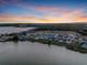 Stunning aerial view of a lakeside community at sunset, showcasing beautiful homes with waterfront access at 16808 Bolsena Dr, Bella Collina, FL 34756