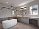 Contemporary bathroom with a soaking tub, glass shower, and floating vanity with a round mirror at 16808 Bolsena Dr, Bella Collina, FL 34756