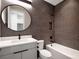 Modern bathroom featuring a stylish vanity, round mirror, and a tiled shower/tub combo at 16808 Bolsena Dr, Bella Collina, FL 34756