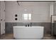Close up of a luxurious soaking tub with matte black fixtures and modern tilework in a bathroom at 16808 Bolsena Dr, Bella Collina, FL 34756