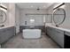 Modern bathroom showcasing a freestanding tub, sleek grey vanities, and stylish black fixtures at 16808 Bolsena Dr, Bella Collina, FL 34756