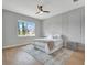 Bright bedroom featuring wood floors, decorative wall paneling, and a large window with a view at 16808 Bolsena Dr, Bella Collina, FL 34756