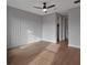 Cozy bedroom features wood floors, decorative wall molding, ceiling fan, and closet at 16808 Bolsena Dr, Bella Collina, FL 34756