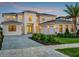 Elegant two-story home features a light stone facade, paved driveway and a spacious three-car garage at 16808 Bolsena Dr, Bella Collina, FL 34756