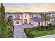 Stunning home with a stone facade, manicured lawn, and gorgeous sunset views over the lake at 16808 Bolsena Dr, Bella Collina, FL 34756