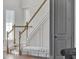 Well-lit foyer showcasing a staircase with wooden handrail and an accent bench that adds elegance to the entrance at 16808 Bolsena Dr, Bella Collina, FL 34756