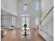 Bright and spacious foyer featuring a staircase, light hardwood floors, and stylish furnishings, offering an inviting atmosphere at 16808 Bolsena Dr, Bella Collina, FL 34756