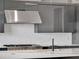 Modern kitchen has white backsplash, stainless steel appliances, and sleek gray cabinetry with a center island at 16808 Bolsena Dr, Bella Collina, FL 34756