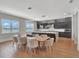 Modern kitchen boasts sleek gray cabinetry, center island with a waterfall edge, and an adjacent dining area with water views at 16808 Bolsena Dr, Bella Collina, FL 34756