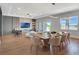 Open-concept living and dining area features modern decor, a large dining table, and views of the lake at 16808 Bolsena Dr, Bella Collina, FL 34756