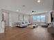 Spacious living room with wood floors, natural light, contemporary decor, and comfortable seating at 16808 Bolsena Dr, Bella Collina, FL 34756